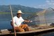 Burma / Myanmar: A leg rowing Intha fisherman shows off his skills with a large conical fish trap at Inle Lake, Shan State